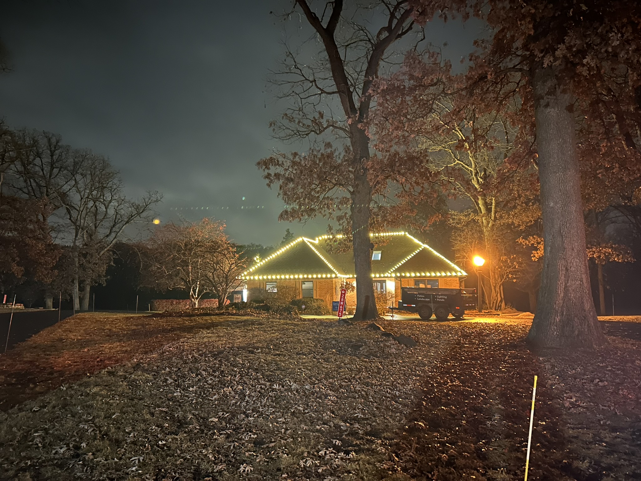 Ranch home outlined in warm white Christmas roofline lights